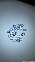 Group of loose oval Tanzanite gemstones on white surface