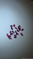 Group of loose marquise-cut rubies on flat surface
