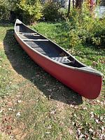 Full side view of red fiberglass canoe
