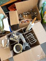 View of both boxes showing toast rack, rolling pin, bagged spoons and assorted items