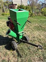Front view showing green hopper, red engine, wheels, tow bar