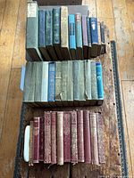 Three stacks of vintage hardcover books showing colours and wear