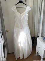 Front view of full-length handmade wedding dress on hanger