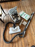 Kenmore canister body, hose, wand, powerhead, bag pack on floor