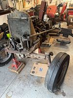 Front view of disassembled tractor with radiator, front axle, wheels