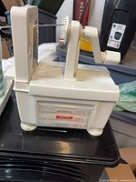 Front view of white spiralizer with handle and blade in place