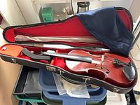 Violin in hard case with bow, silk bag visible