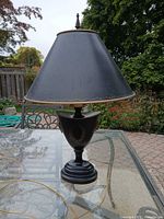 Full view of lamp on table showing shade, base and finial