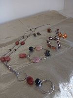 Overview of necklace, bracelets, earrings, ring on fabric