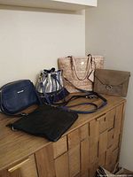 All five purses displayed on dresser