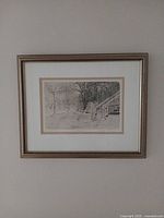 Framed etching on wall showing full frame and mat