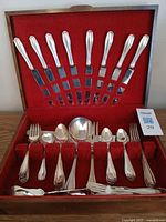 Overall view of flatware set in open chest showing knives, forks, spoons