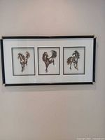 Full view of framed artwork showing all three horse cutouts and frame style