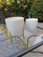 Both planters on glass table showing size comparison