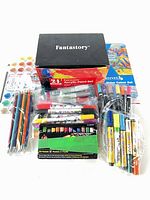 Group shot of all art supplies including paint sets, markers, pencils and pastels