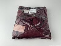 Dress folded inside original sealed retail poly bag with tags visible