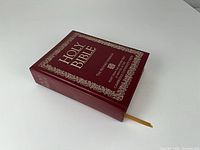 Burgundy leatherette Bible closed showing gilt border and ribbon marker