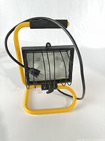 Front view showing yellow stand, black light housing, wire guard, cord