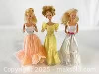 Front view of all three Barbie dolls in respective dresses