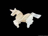 Side view of alabaster unicorn figurine showing overall shape and translucent stone