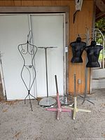 Overall lot showing wire dress form, chrome hook rack, two black torso mannequins on stands, three cross bases
