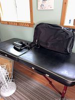 Full view of massage table with carry bag and accessories on top