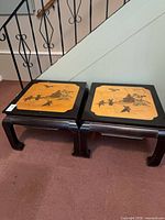 Pair of black lacquer end tables with painted tops