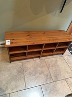Full view of wooden shoe storage bench showing 8 cubbies