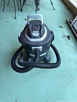 Front view of black Shop-Vac 5 gal wet/dry vacuum with hose attached