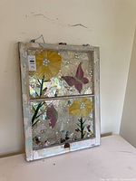 Full view of stained glass mosaic window panel leaning against wall