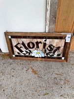 Full view of stained glass panel leaning against wall showing entire design and frame