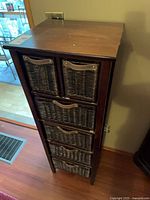 Front view of wood frame storage cabinet with six wicker drawers