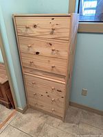 Full front view of tall narrow six-drawer pine dresser