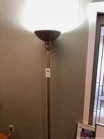 Full view of torchiere floor lamp lit
