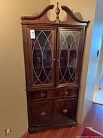 Full view of corner china cabinet showing upper glass doors, centre drawer, lower cupboard