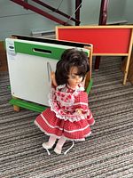Easel folded open with doll standing in front