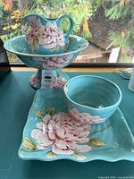 All four ceramic pieces grouped together showing turquoise color and peony motif