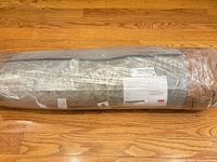 Runner rug in factory roll, plastic wrap with product label visible
