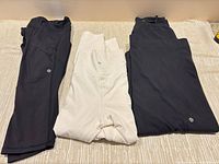 Three pairs of pants laid flat showing colors and logos