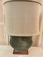Front view of one bronze lamp with shade