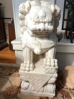Full view of marble guardian lion on plinth
