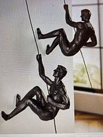 Two resin climbing figures displayed on white background