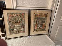 Both framed chromolithograph prints on table
