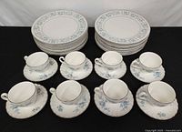 Stacked dinner plates and arranged cups with saucers