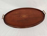 Top view showing entire oval tray, brass handles, inlay, and wood grain