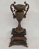 Front view of urn candle holder showing scroll handles and marble base