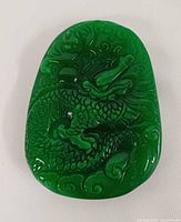 Front of carved green jadeite pendant with dragon design