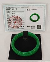 bracelet on black pad beside certificate