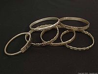 All six silver-tone bangles group view