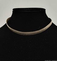 Necklace displayed on black jewelry bust